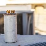 AC capacitor failure symptoms showing a corroded and deteriorated air conditioner capacitor