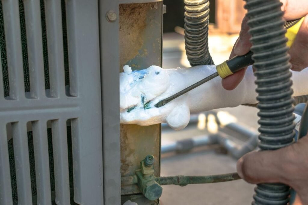 AC keeps freezing Houston technician removing ice buildup from outdoor AC unit