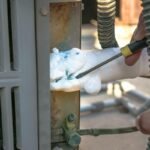 AC keeps freezing Houston technician removing ice buildup from outdoor AC unit