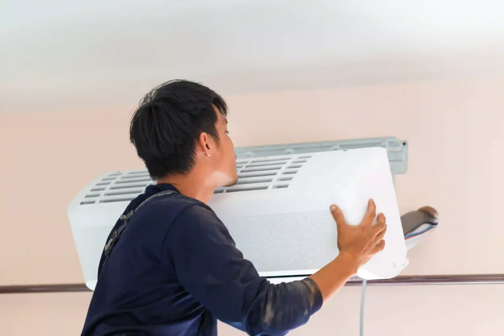 How long do AC units last in Houston? HVAC technician installing a wall-mounted air conditioning unit in a Houston home.