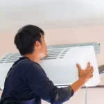 How long do AC units last in Houston? HVAC technician installing a wall-mounted air conditioning unit in a Houston home.