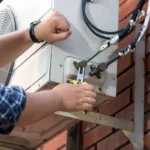 How to fix heating and air conditioning system with a technician repairing an outdoor AC condenser