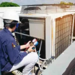 Professional technician using gauges to how to prepare your HVAC system for the upcoming season.