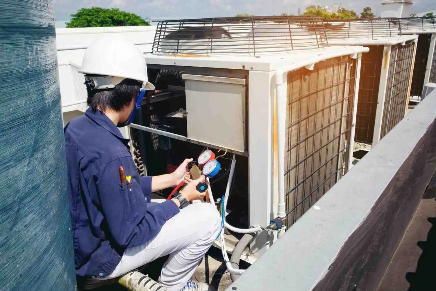 Professional technician using gauges to how to prepare your HVAC system for the upcoming season.