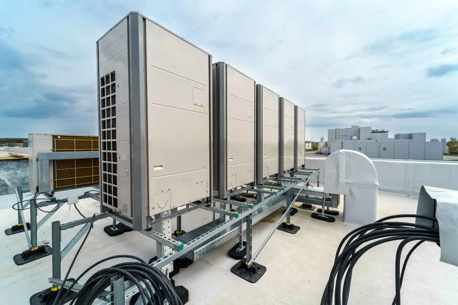 HVAC system components including rooftop commercial condensing units, refrigerant lines, electrical connections, and support framework installation
