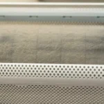 A close-up of a heavily clogged, dusty air purifier barrel showing how does a HEPA filter work by trapping airborne particles.