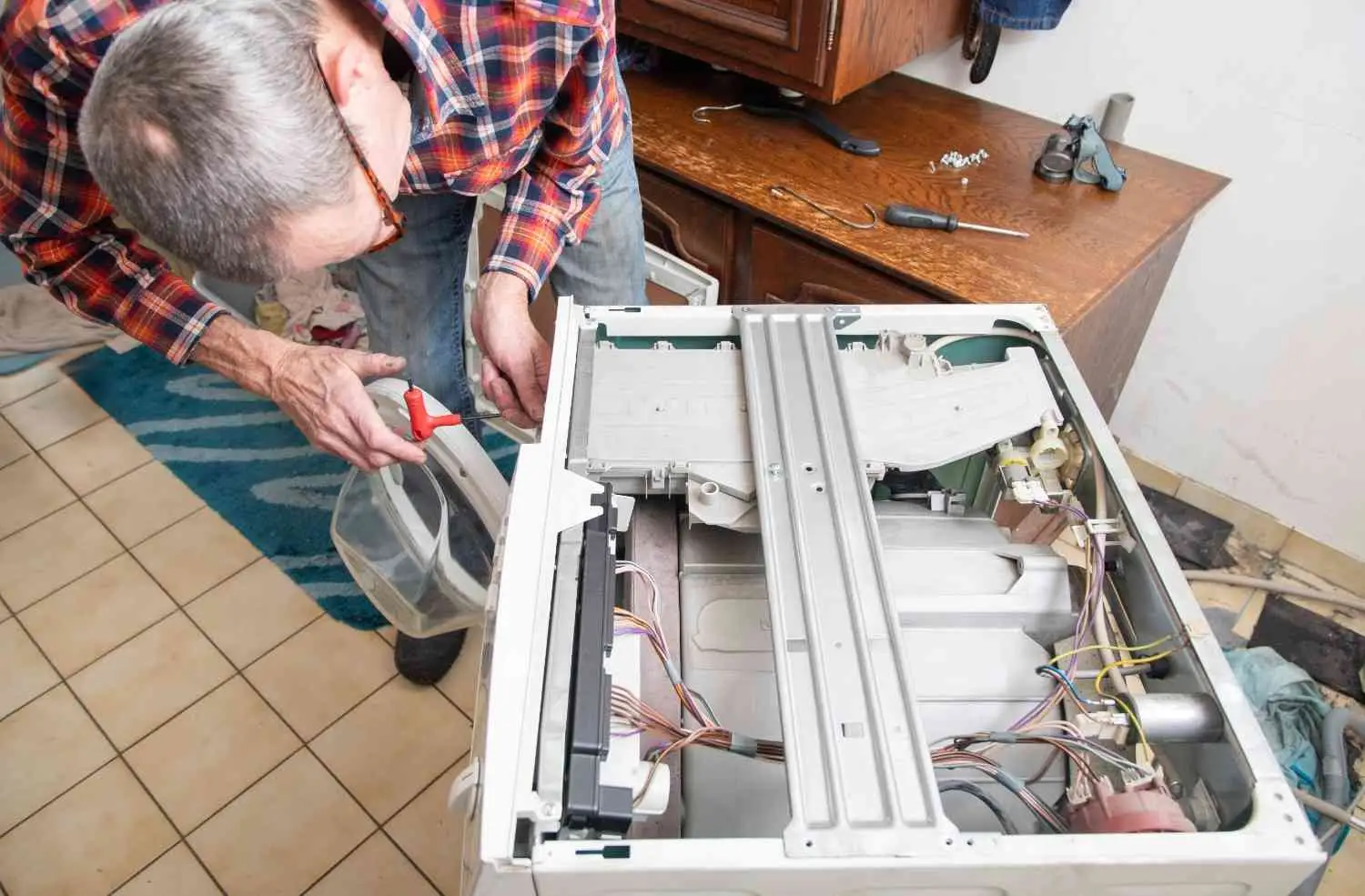An overhead view of a technician working on internal electrical wiring and circuits, illustrating the importance of understanding how to size an electric furnace including its kW, breaker, and wire gauge needs.