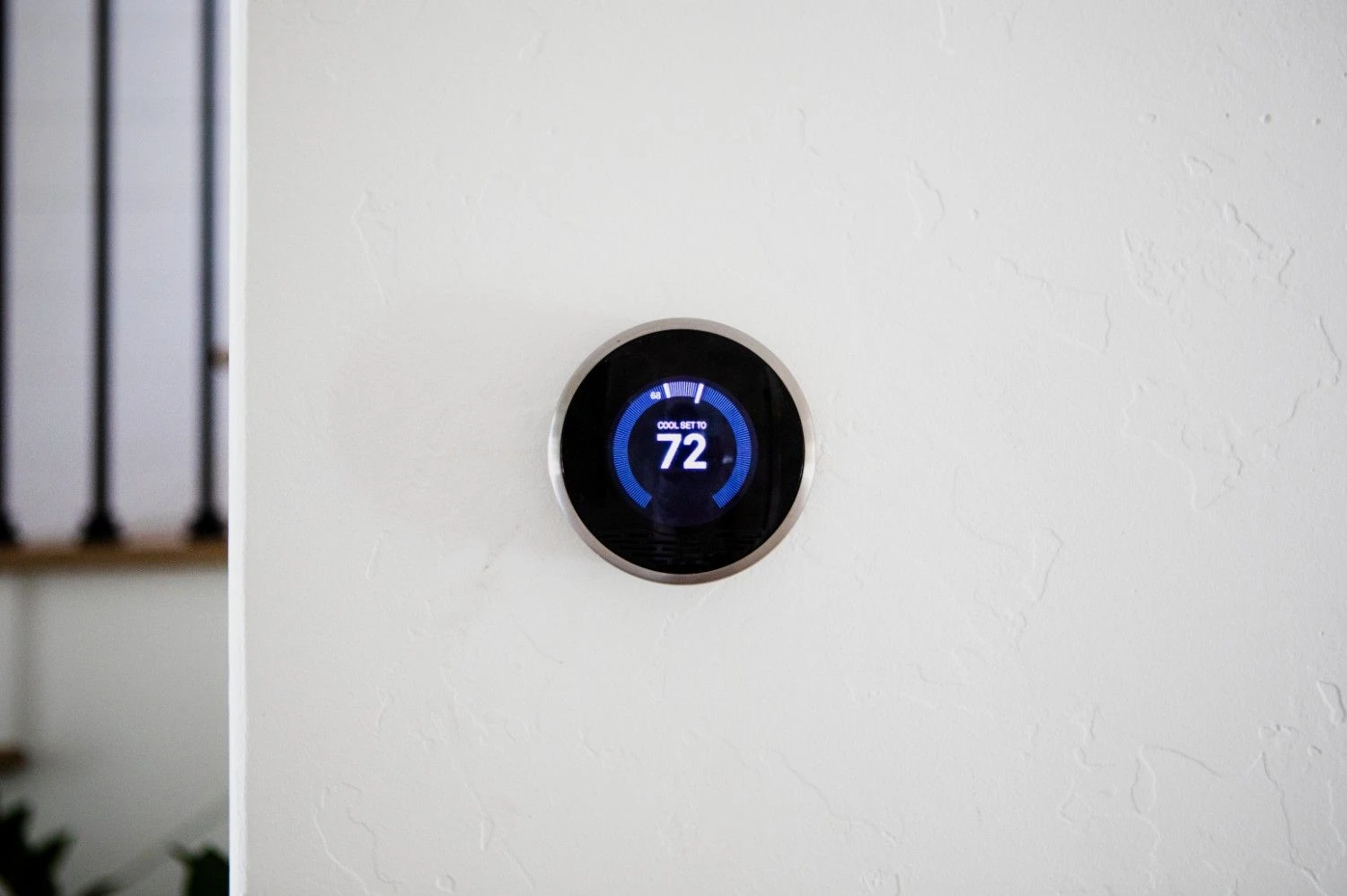A round Nest smart thermostat mounted on a white wall displaying a cooling temperature of 72 degrees, perfect for helping readers determine: Is Your HVAC System Nest-Compatible?
