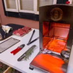 A high-heat tabletop infrared broiler glowing bright orange, used to demonstrate what is a furnace style cooking appliance for searing steaks.