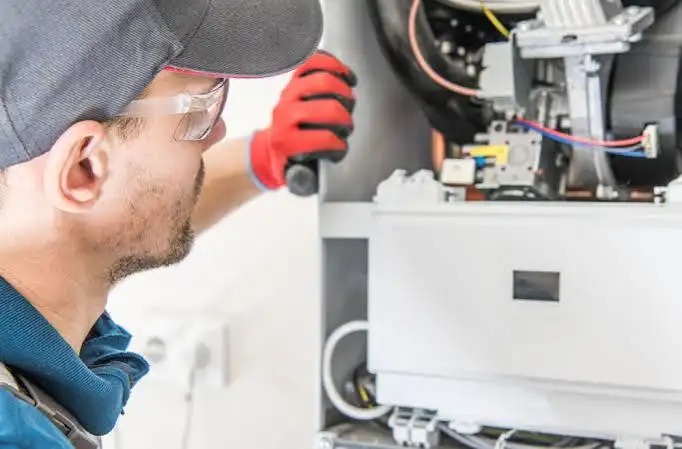 HVAC technician examining components to determine what to check before resetting your furnace