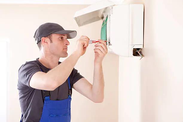 Homeowner checking non-functioning AC unit during Houston summer heat