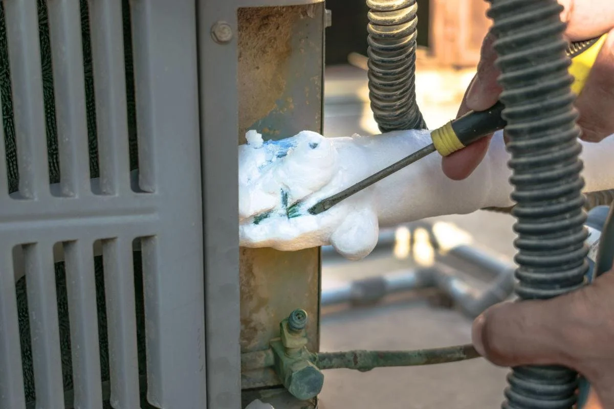 AC keeps freezing Houston technician removing ice buildup from outdoor AC unit
