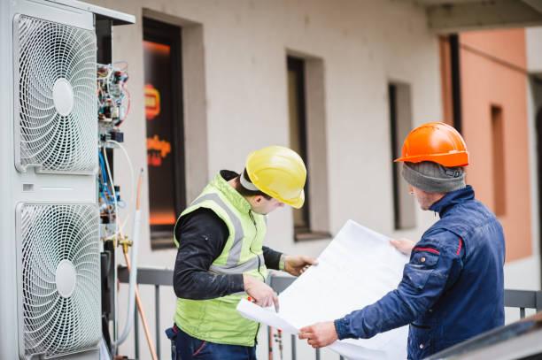 Homeowner consulting with AC technician about maintenance plan options