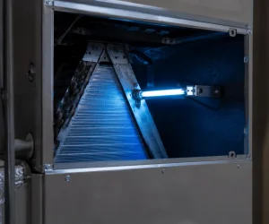 Installed HVAC ultraviolet lamp glowing blue near evaporator coils to evaluate are UV lights