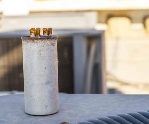 AC capacitor failure symptoms showing a corroded and deteriorated air conditioner capacitor