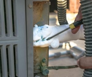 AC keeps freezing Houston technician removing ice buildup from outdoor AC unit