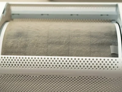 A close-up of a heavily clogged, dusty air purifier barrel showing how does a HEPA filter work by trapping airborne particles.