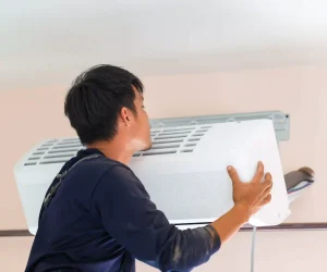 How long do AC units last in Houston? HVAC technician installing a wall-mounted air conditioning