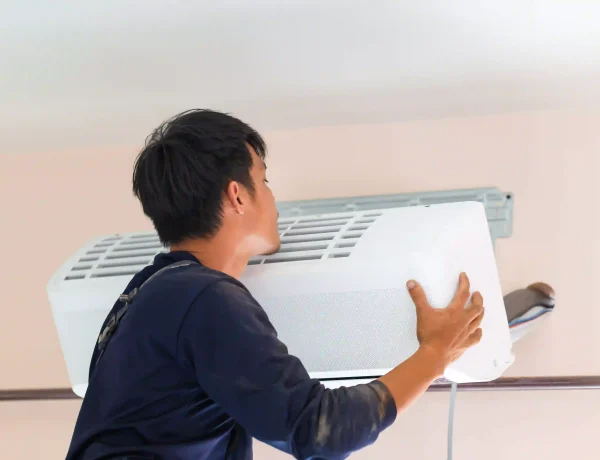 How long do AC units last in Houston? HVAC technician installing a wall-mounted air conditioning unit in a Houston home.
