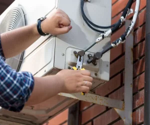 How to fix heating and air conditioning system with a technician repairing an outdoor AC condenser