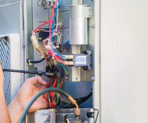 A technician carefully wiring complex electrical components and terminal blocks, demonstrating an