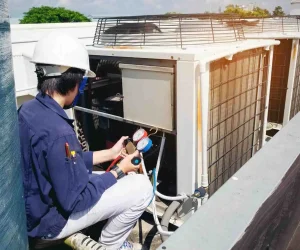 Professional technician using gauges to how to prepare your HVAC system for the upcoming season.