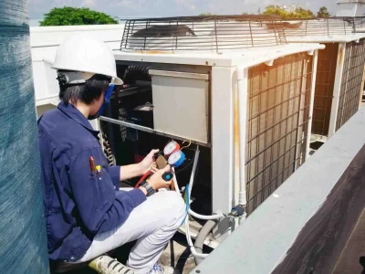 Professional technician using gauges to how to prepare your HVAC system for the upcoming season.