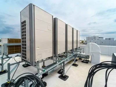 HVAC system components including rooftop commercial condensing units, refrigerant lines, electrical connections, and support framework installation