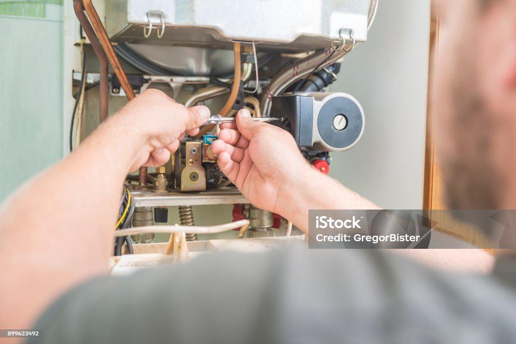 Technician repairing furnace ignition system