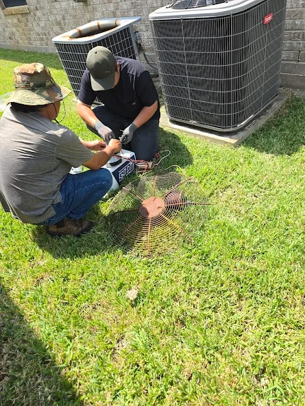 two hvac technicians repairing outdoor air conditioner unit