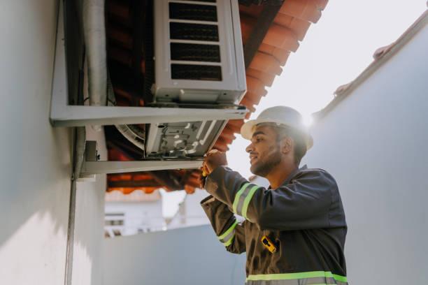 Professional HVAC technician inspecting air conditioning system